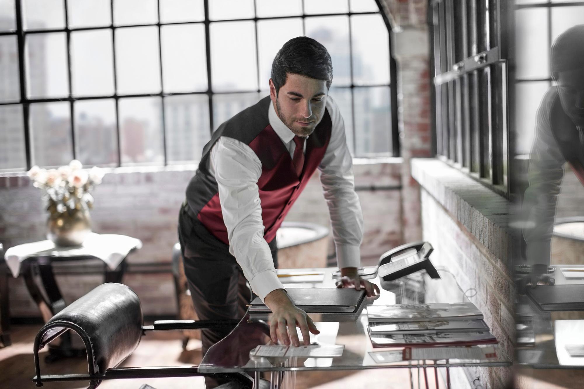 Butler in hotel room, cleaning the table